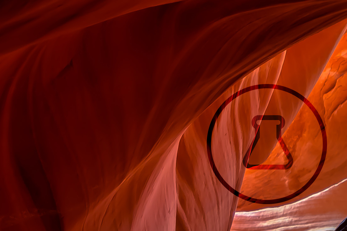 Close up image of red rock with beaker in circle icon 
